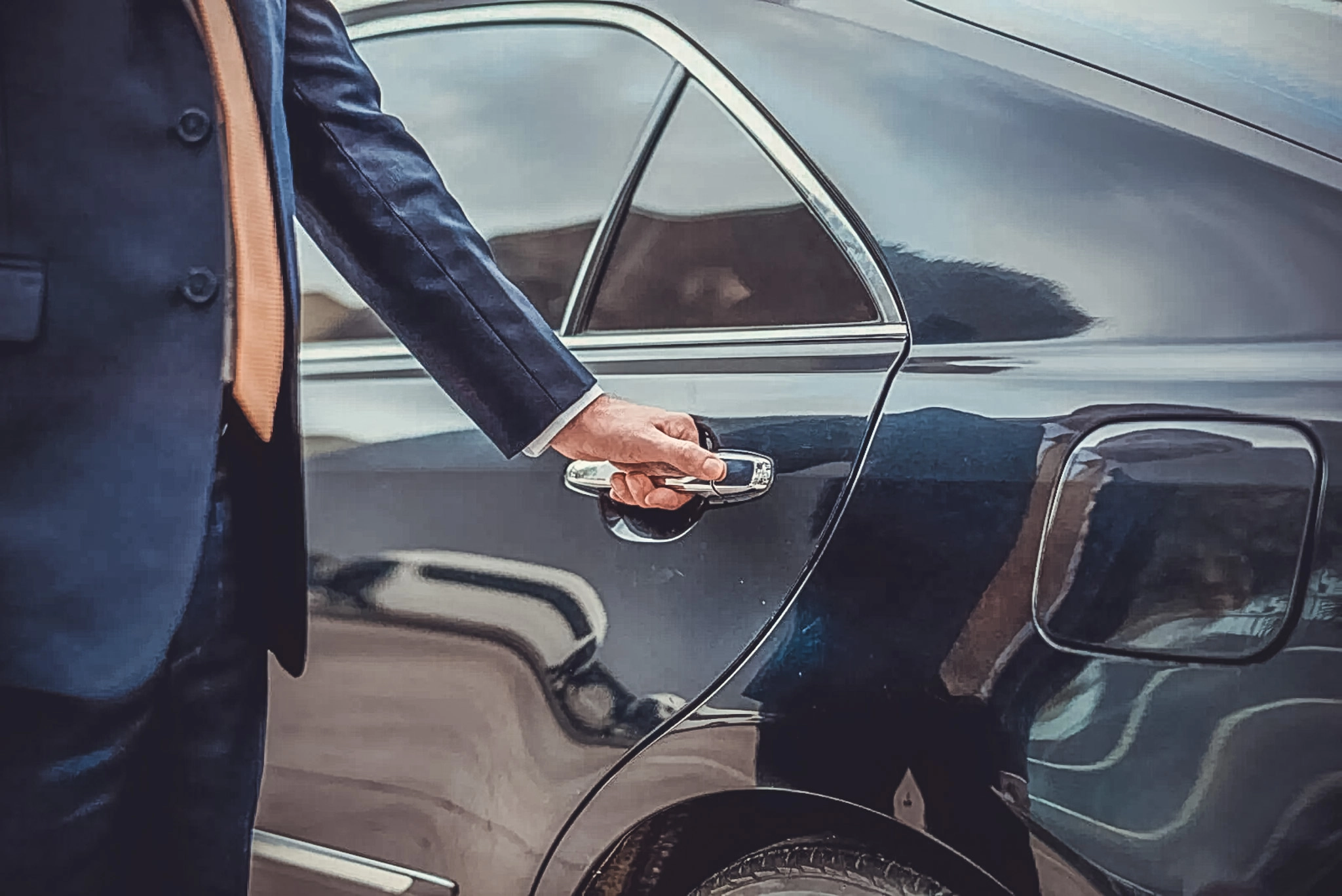 Chauffeur opening the door for a business traveller
